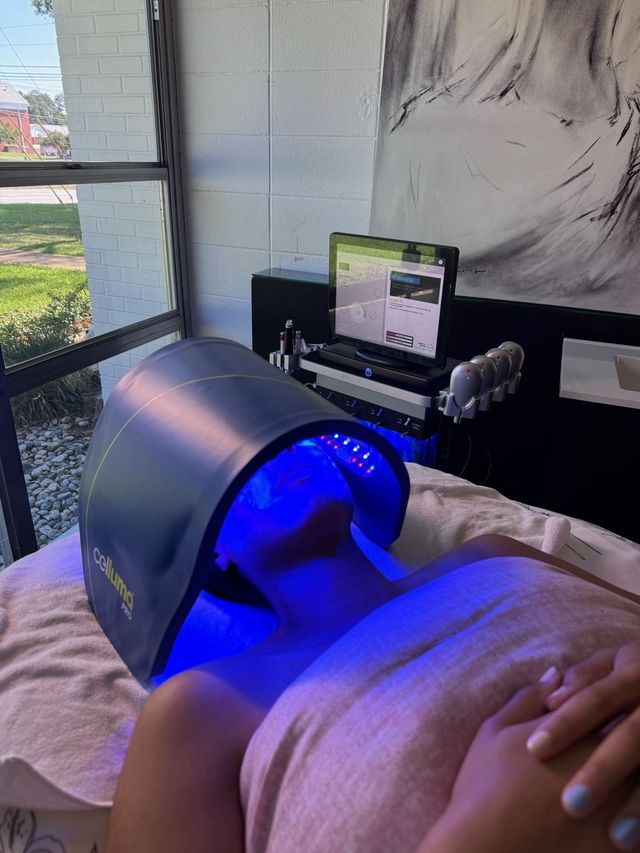 Client relaxing under the Celluma LED light therapy panel